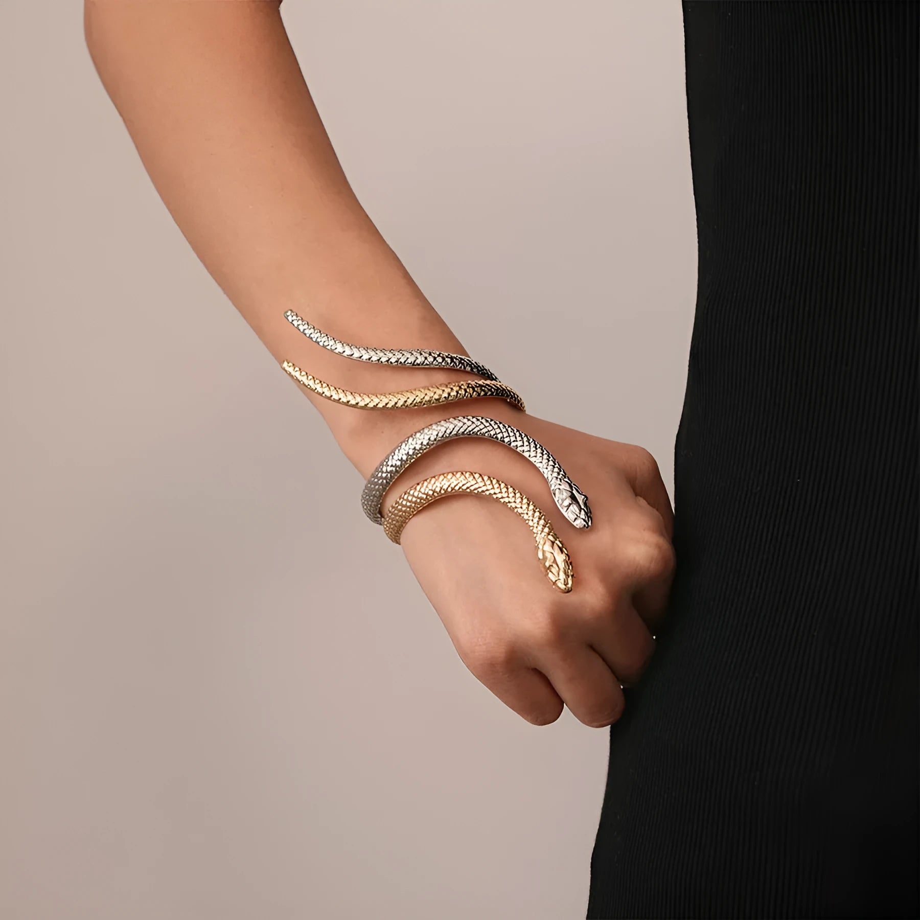 Gold tone snake-inspired bracelet and ring set with exaggerated twisted winding design on white background