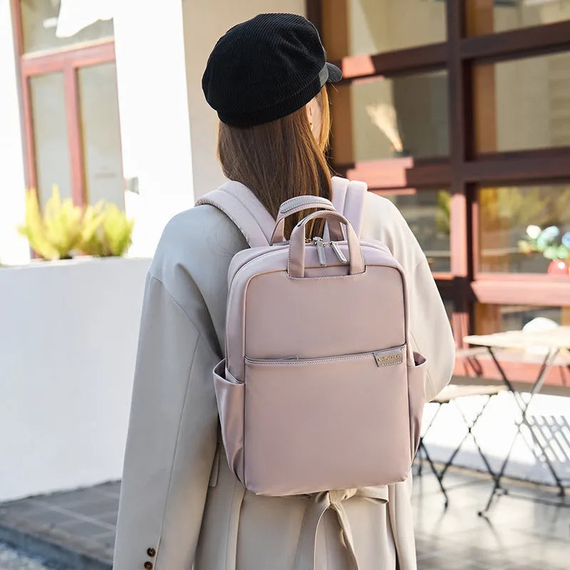 Women's canvas travel backpack in apricot colour showing multiple internal compartments including laptop section