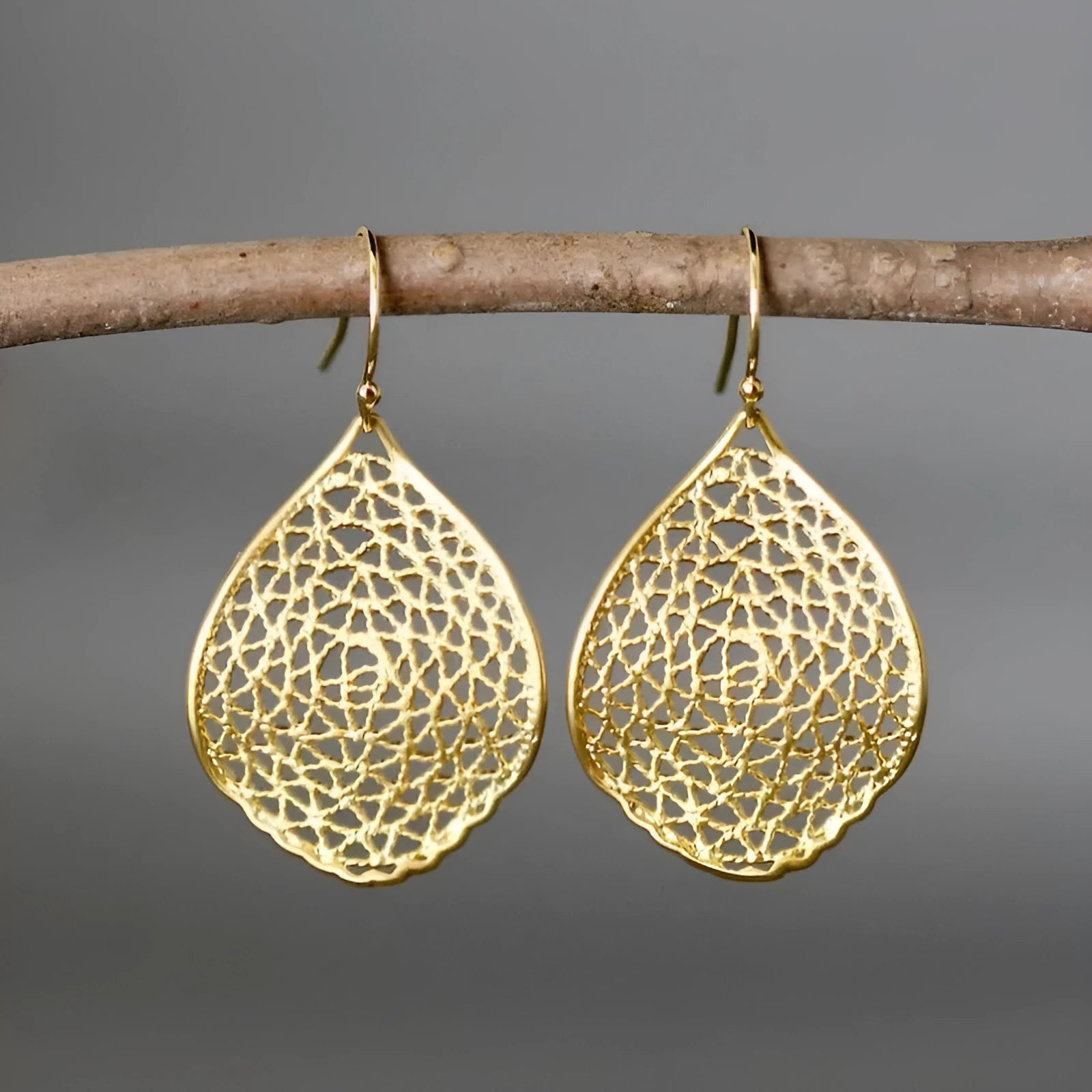 Gold-coloured retro-style drop earrings with a hollow leaf pendant design.