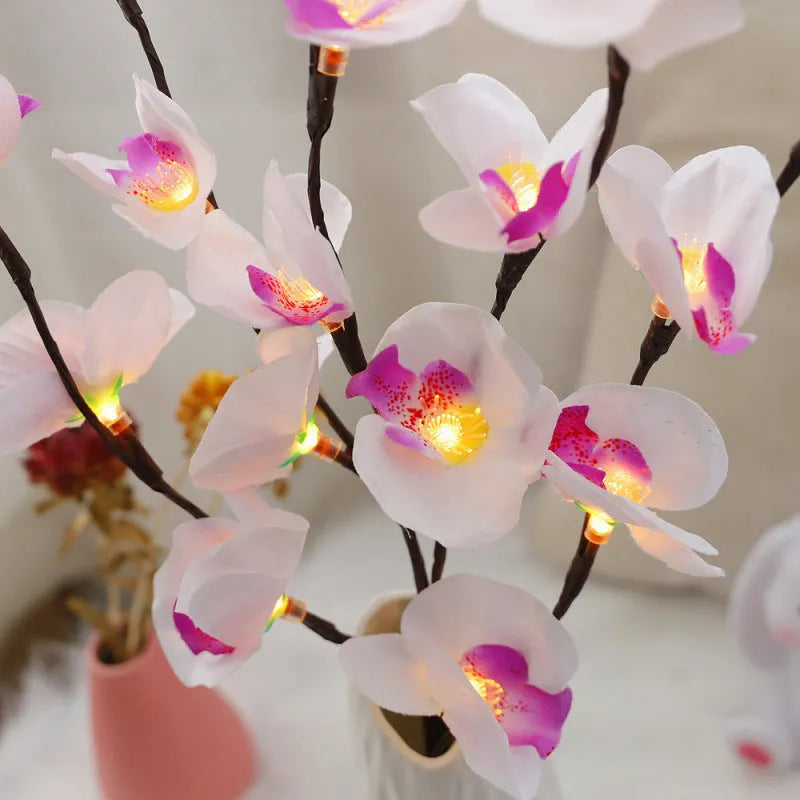 Pink LED phalaenopsis orchid branch decorative light, 65cm long, with warm white illumination on battery power.
