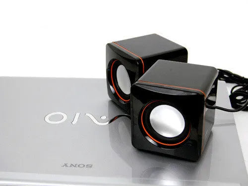 Small black square computer speaker with USB cable for desktop audio