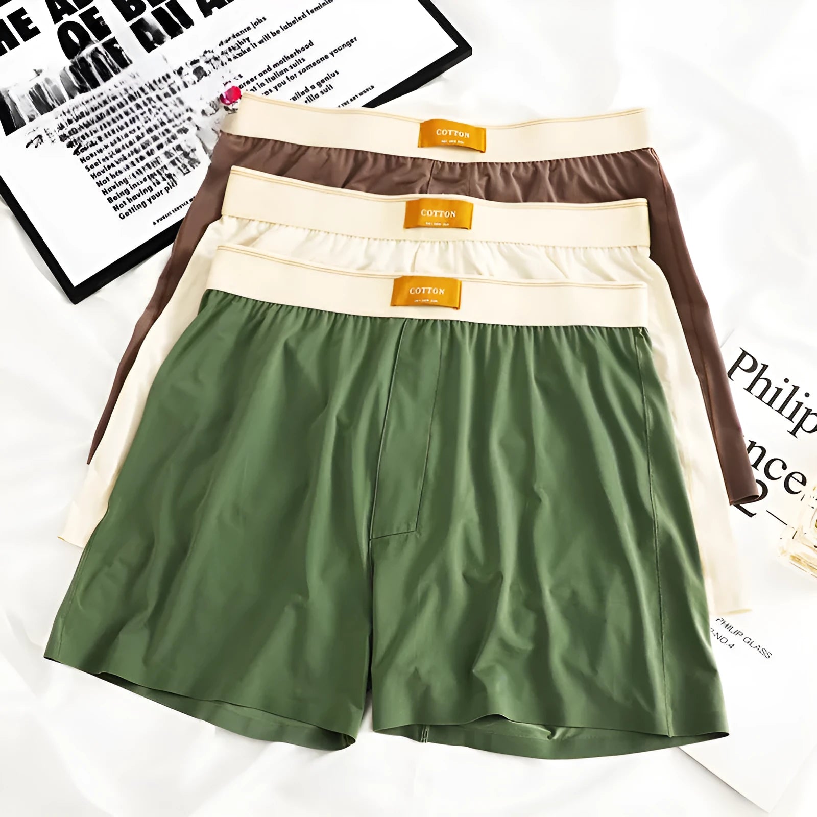Pack of men's solid colour ice silk boxer shorts showing loose fit and mid-waist design.