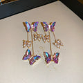 Blue purple butterfly earrings with silver needle crystal flowers and tassel detailing on alloy base