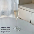 Six French crystal champagne glasses in various designs on dining table
