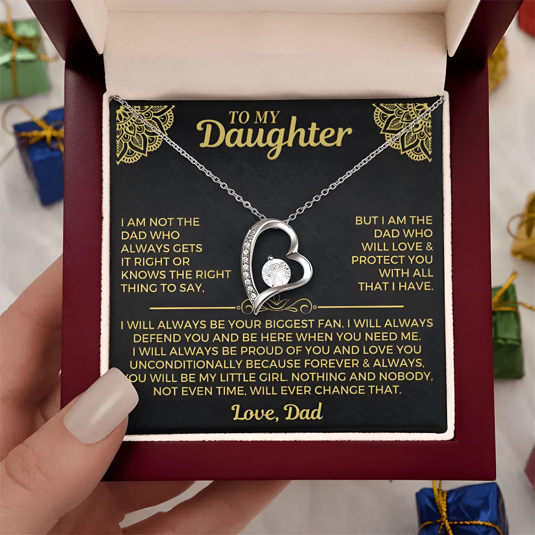 Silver and gold hollow heart necklace pendant presented on a card inside an open gift box.