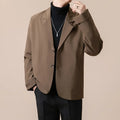 Man wearing a loose fit apricot coloured suit jacket with long sleeves.