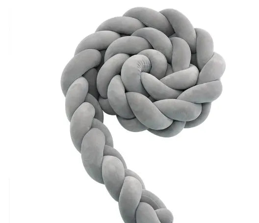 Braided knot pillow cushion bumper for infant crib in spandex velvet, shown in a light colour.