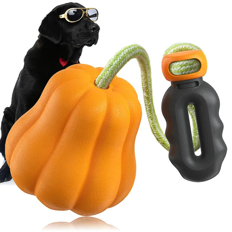 Large orange pumpkin-shaped plastic dog chew toy with an attached rope for throwing