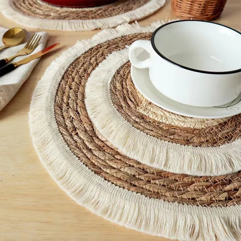 Round Japanese straw placemat with corn rope tassels in natural papyrus colour on wooden table