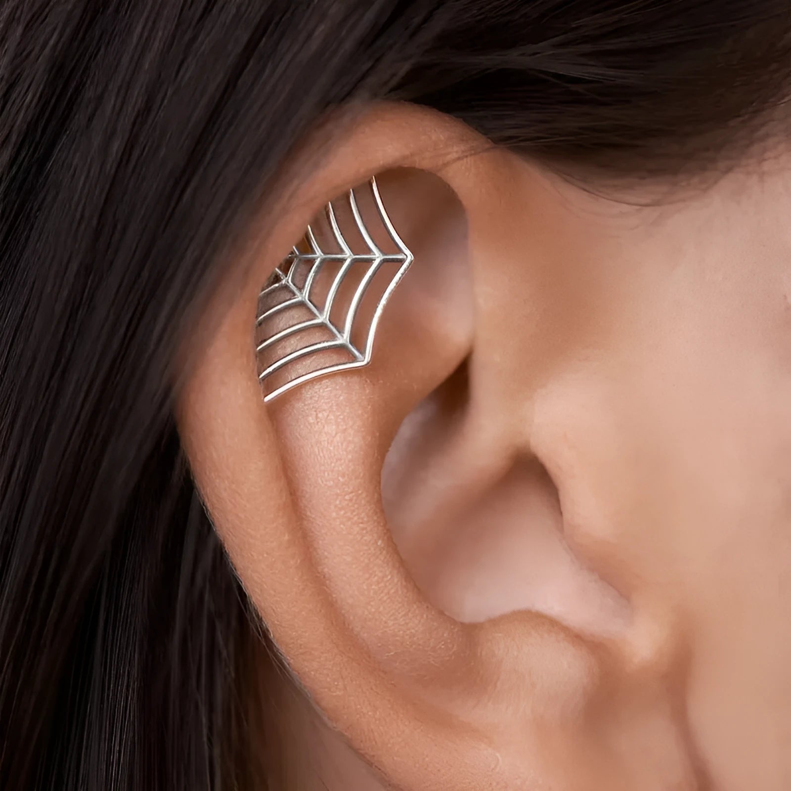Metal spider web stud earrings in electroplated gold or silver finish, geometric mesh design.