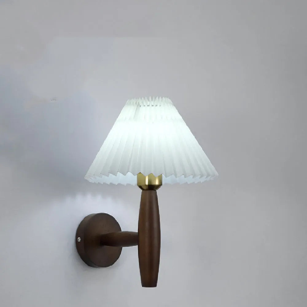 American retro style wall lamp with a walnut wood base and white fabric shade mounted on a wall.