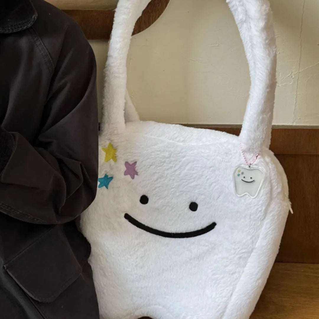 White plush large tooth shoulder tote bag with crossbody strap and zip closure.