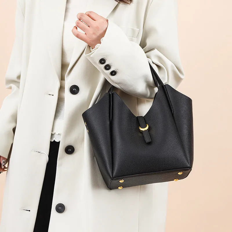 Genuine leather retro bucket handbag for women in beige, showing sewn thread detail and handheld straps.