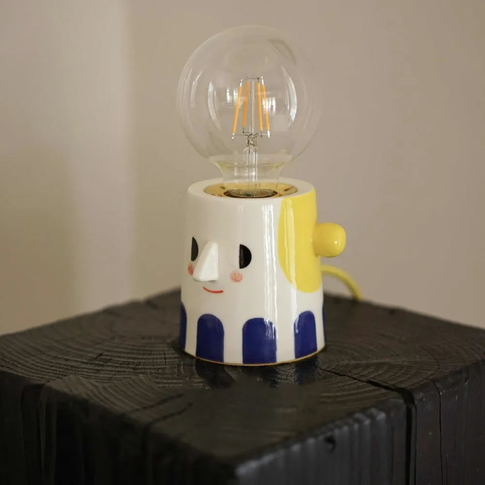 Handmade ceramic bedside lamp with ball headlight shade on wooden surface