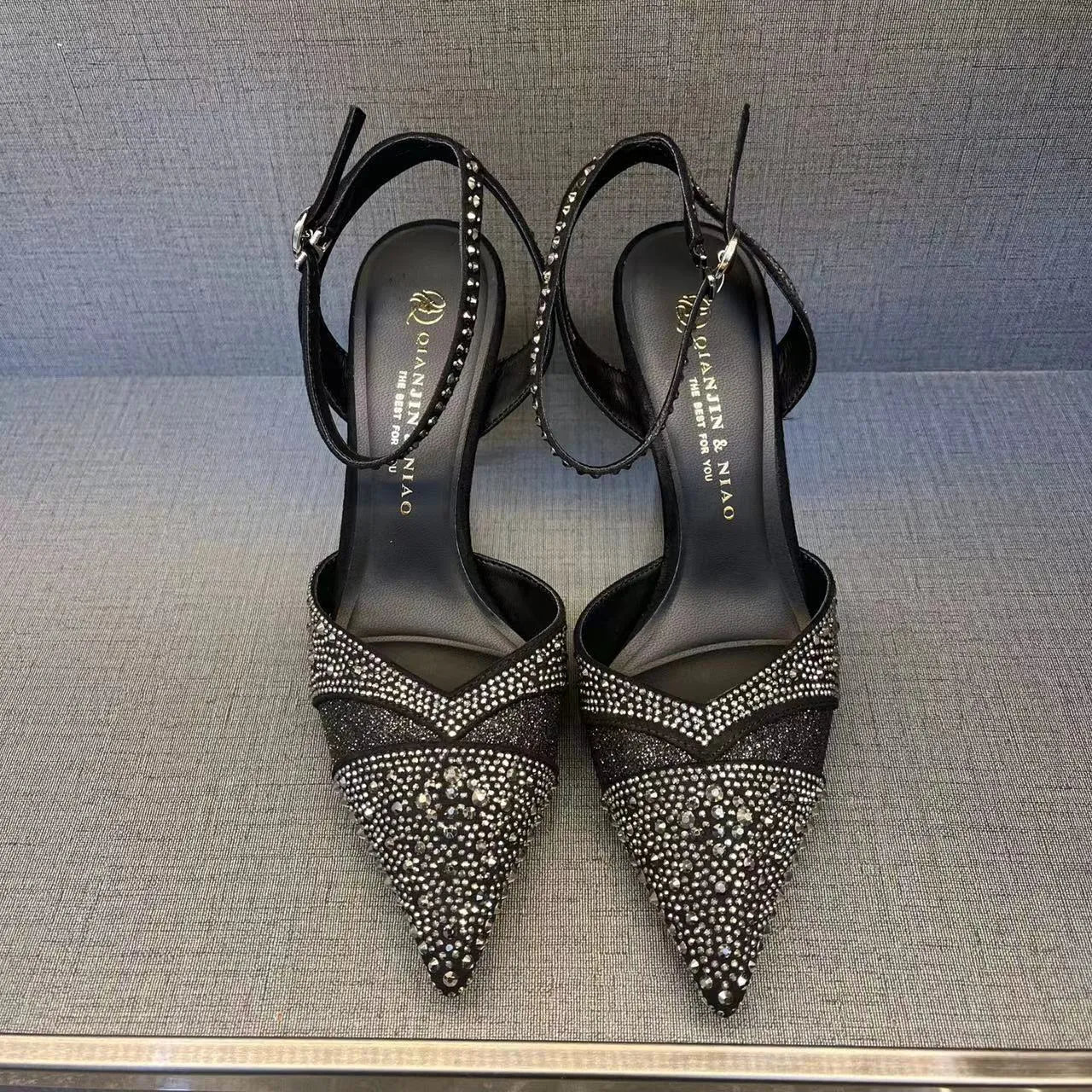 Women's black and silver hollow high heels with red sole and stiletto heel design