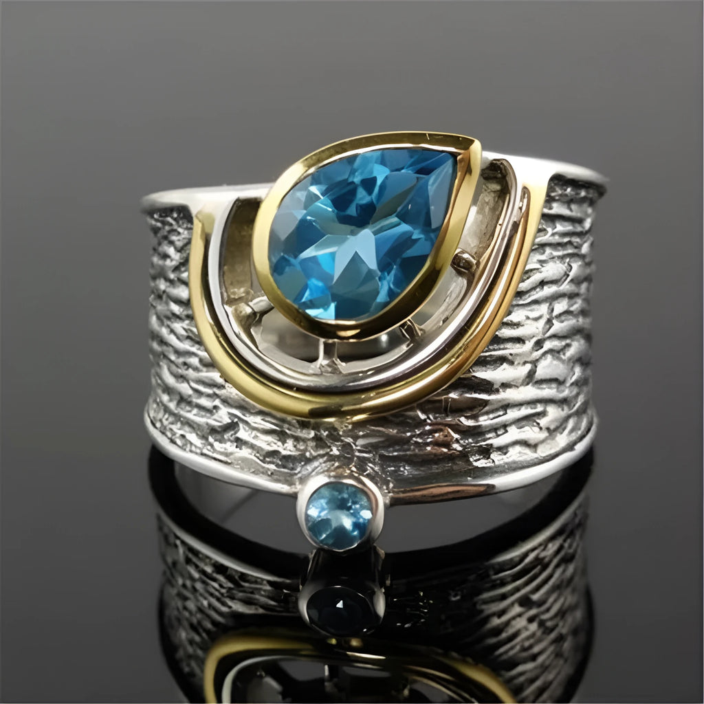 Chinese style blue zircon rhinestone alloy ring in a drop shape on a model's finger.