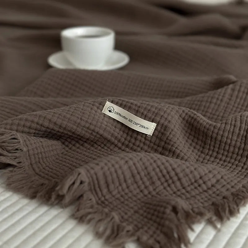 Four-layer gauze cotton blanket with tassel trim in a choice of ten colours and two sizes.