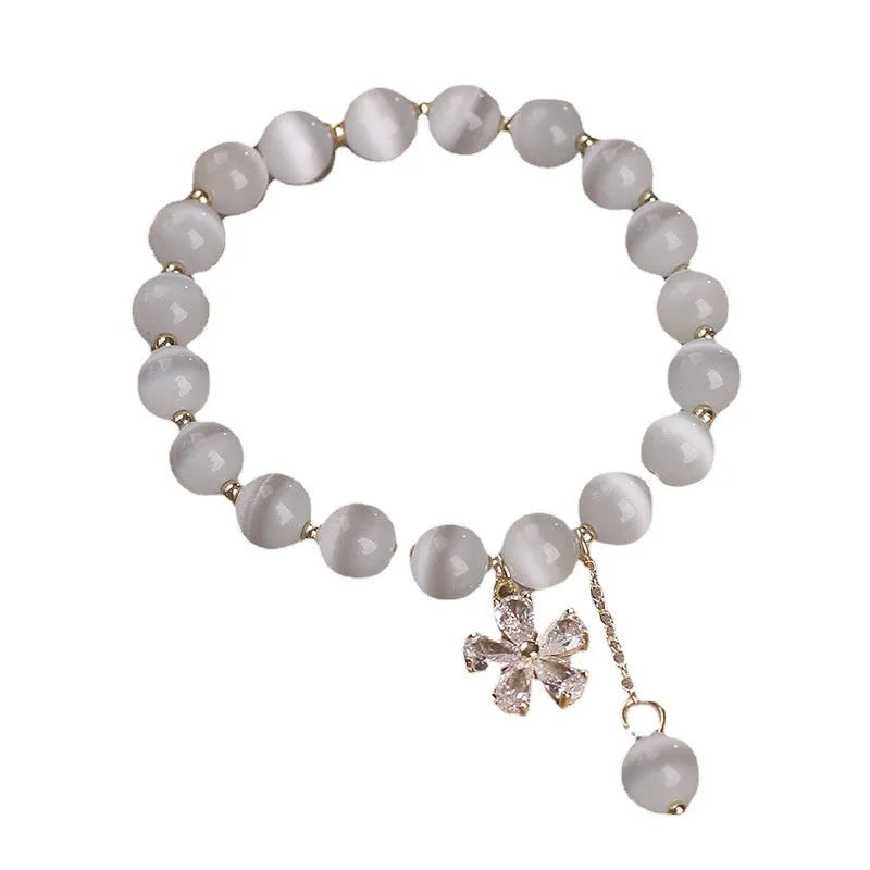 Women's single loop bracelet with white cat's eye stones and decorative tassel featuring morganite safety buckle