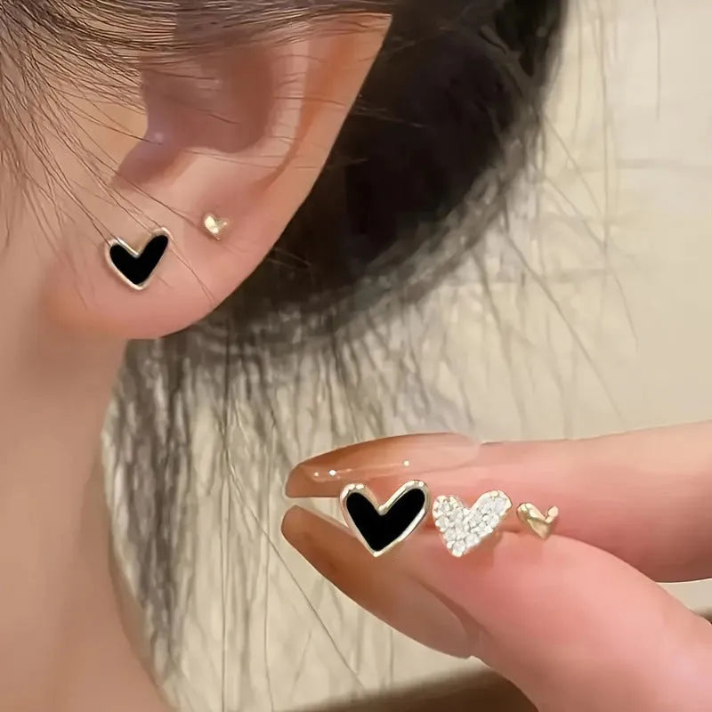 Three pairs of heart-shaped alloy earrings with electroplated finish in gold, black, and pink colours