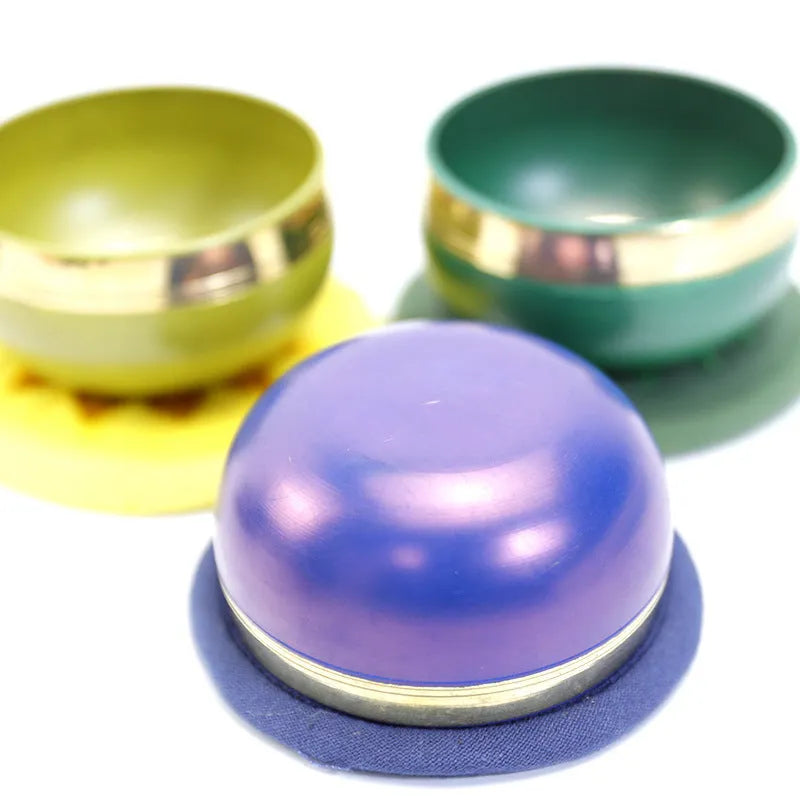 Seven colourful handmade Himalayan-style bowl percussion instruments arranged by size and colour
