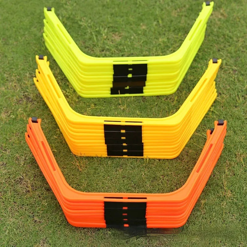 Set of six foldable yellow green and orange hexagon football agility training rings on grass