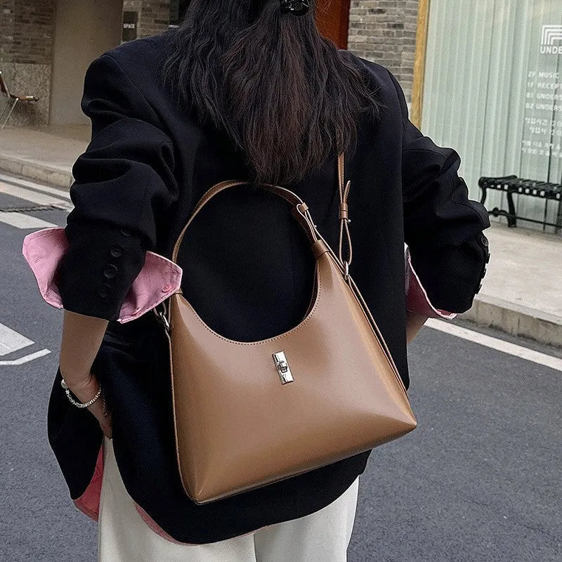 Soft genuine leather dumpling-shaped crossbody shoulder bag in a street style with lock detail