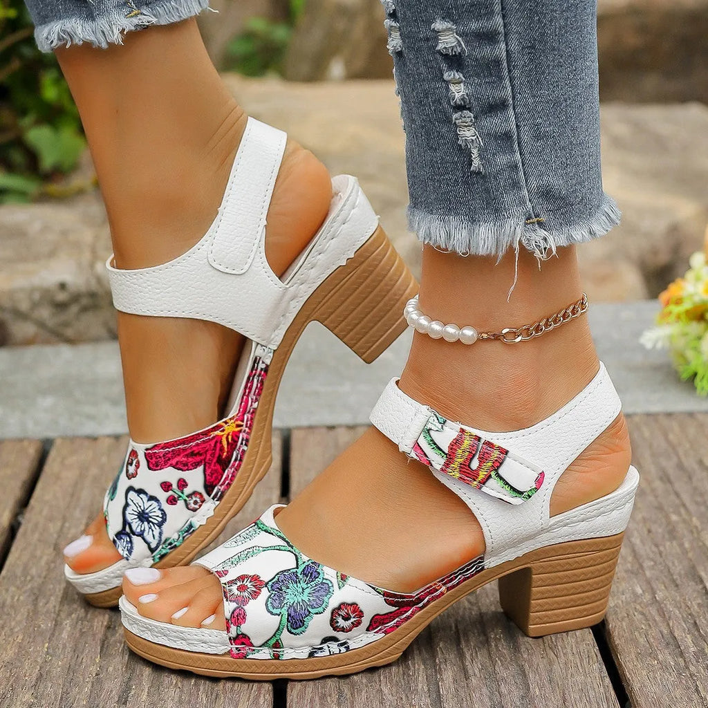 White women's high heel sandals with a Velcro strap closure on a rubber sole.