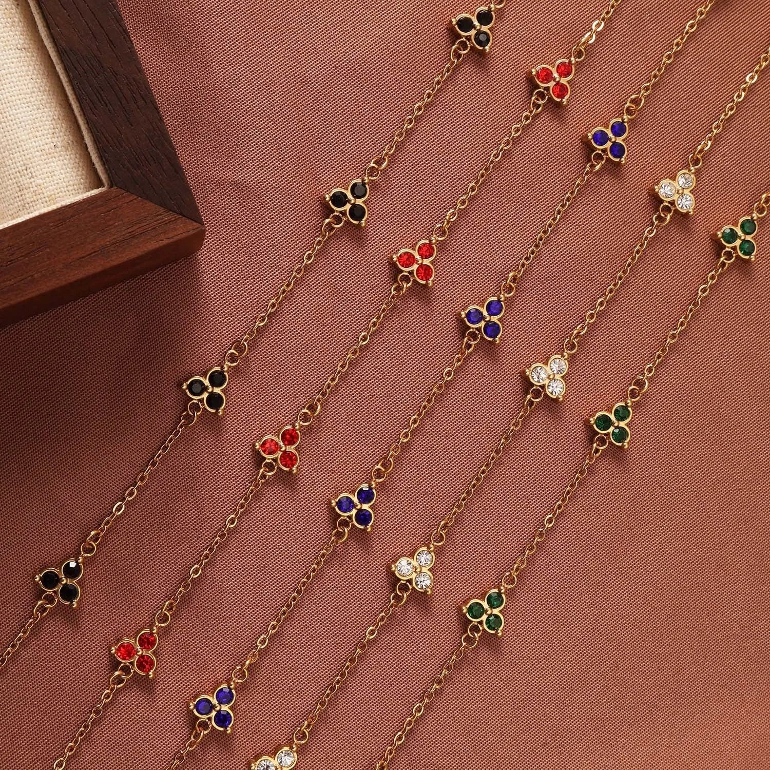 Geometric stainless steel women's bracelet with triangular links and a coloured stone centre.
