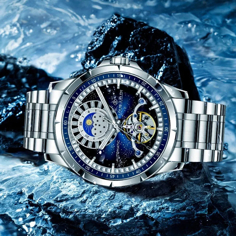 Men's silver automatic mechanical watch with blue dial on stainless steel strap showing butterfly buckle