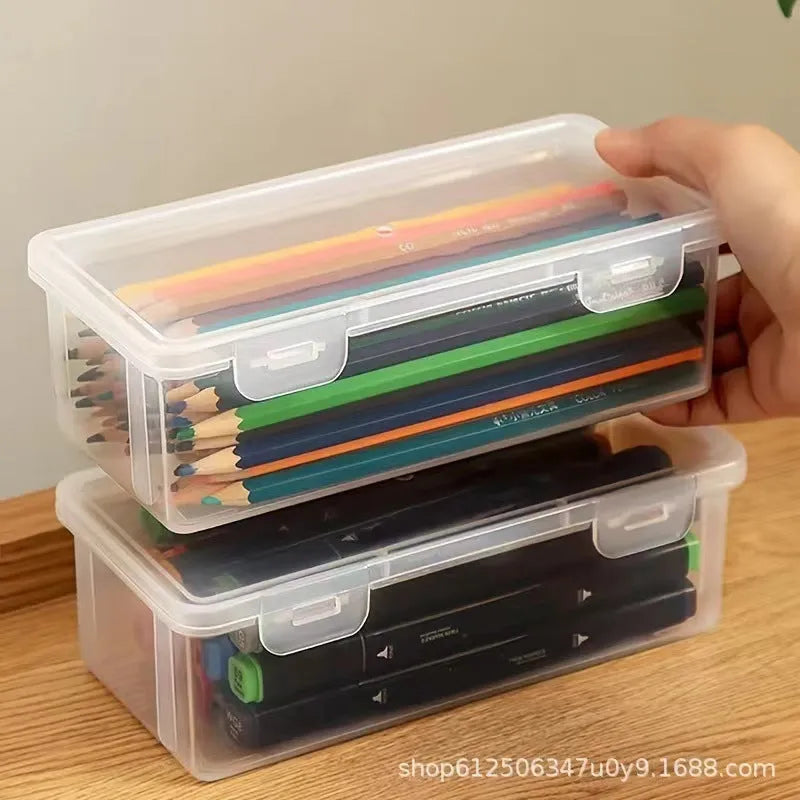 Clear plastic storage box for pencils, colouring leads, and children's crayons on a desk.