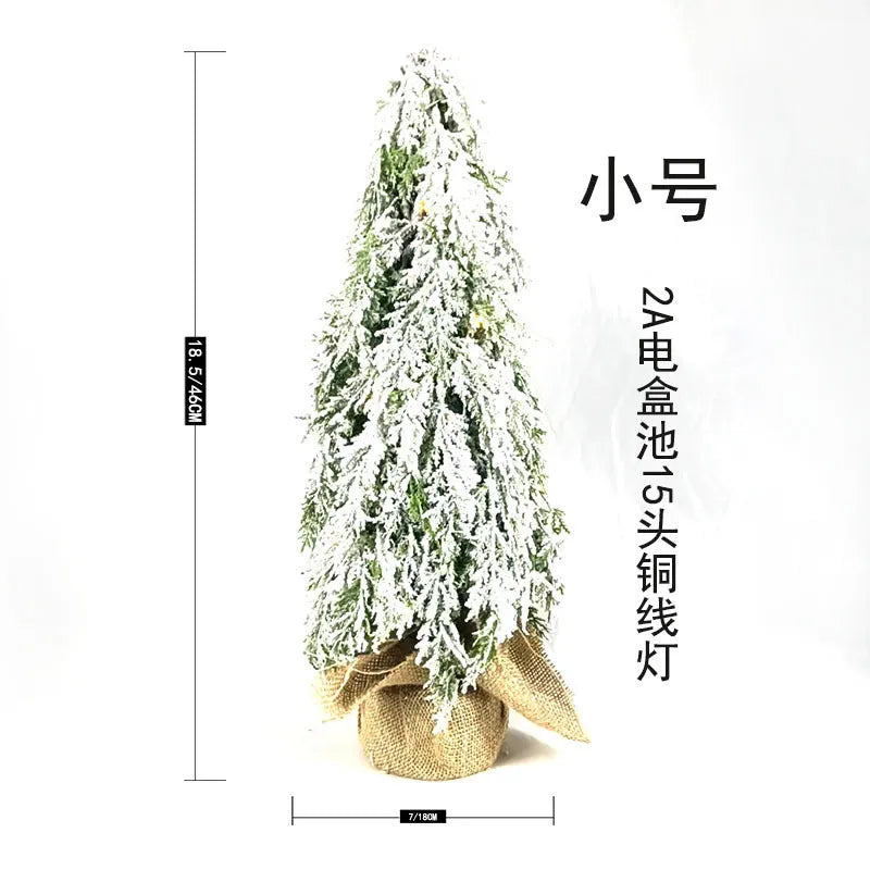 24-inch plastic artificial Christmas tree with snow sprayer and integrated lights on desktop