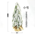 24-inch plastic artificial Christmas tree with snow sprayer and integrated lights on desktop