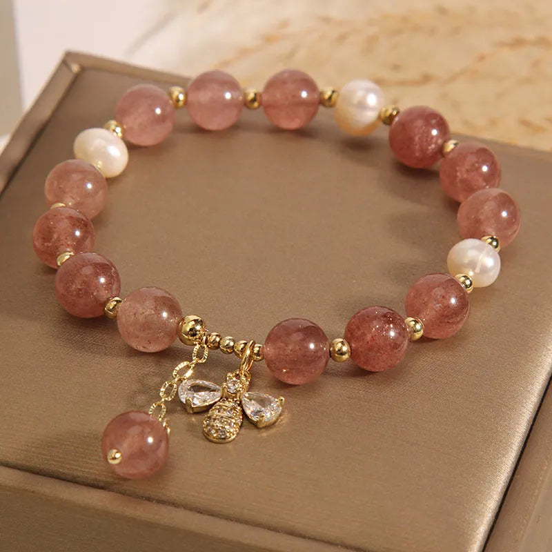 Women's bracelet with freshwater pearls, pink strawberry quartz stones, and a metallic zircon alloy clasp.