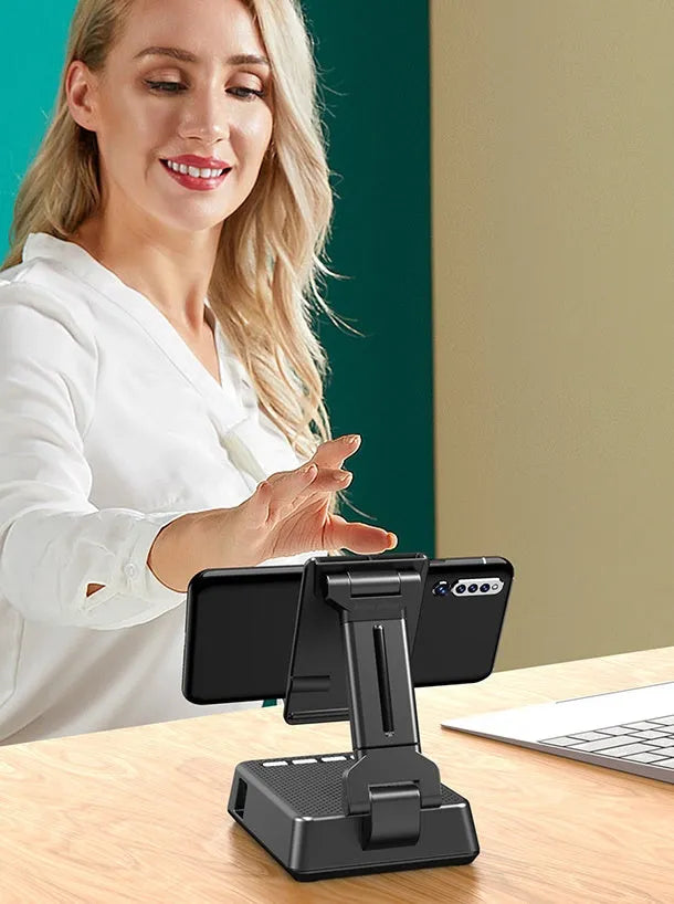 Black mobile phone broadcaster stand with wireless Bluetooth speaker and integrated HD microphone on desk