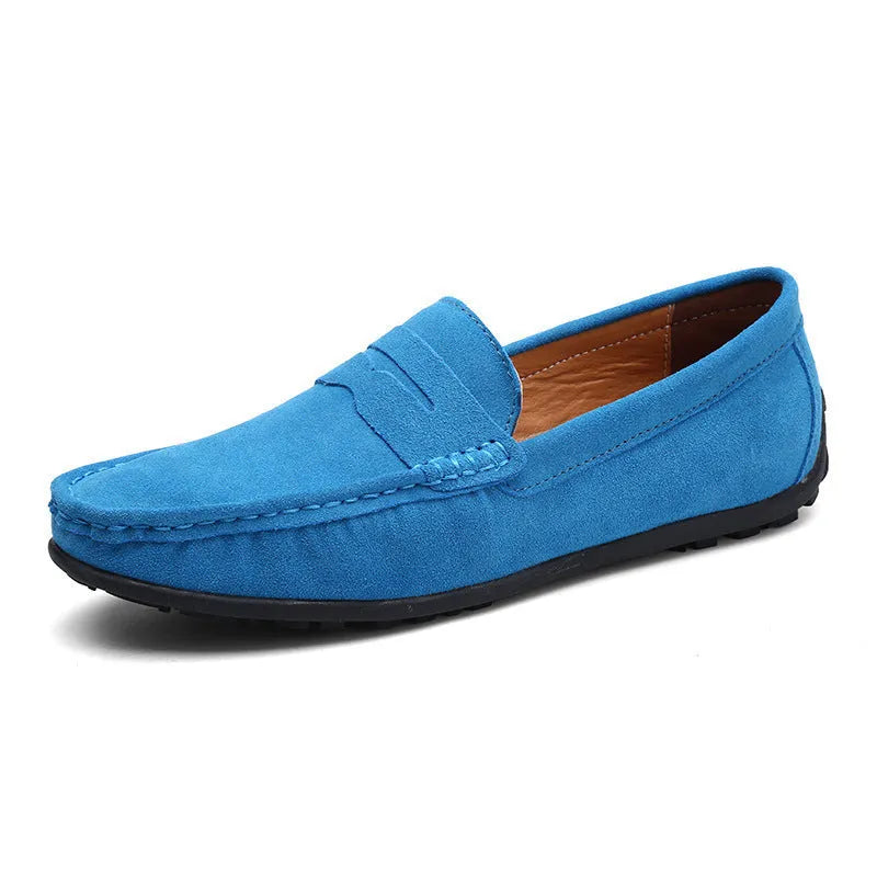 Men's suede leather Gommino loafers in black on a flat rubber sole, showing round toe and sewing line detail.
