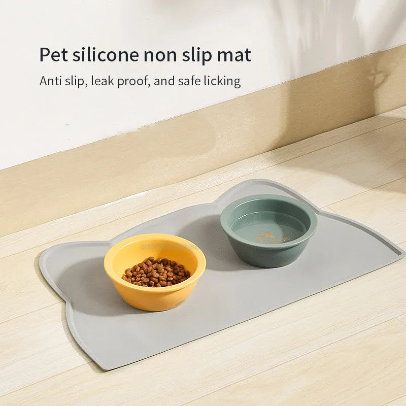 Blue silicone pet feeding mat for dog or cat bowls on a wooden floor.