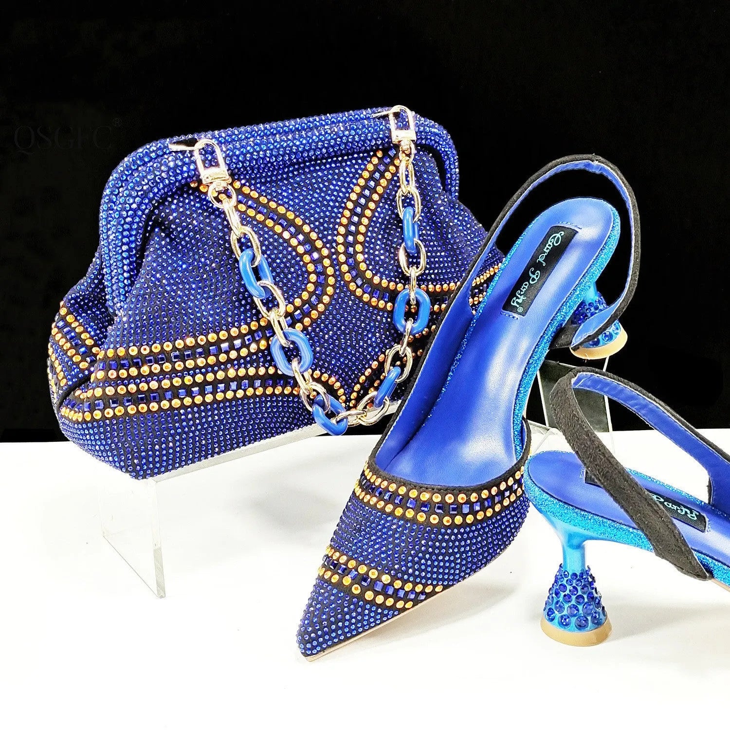 Women's pointed toe high heel shoes with rhinestone detail and a matching small bag.