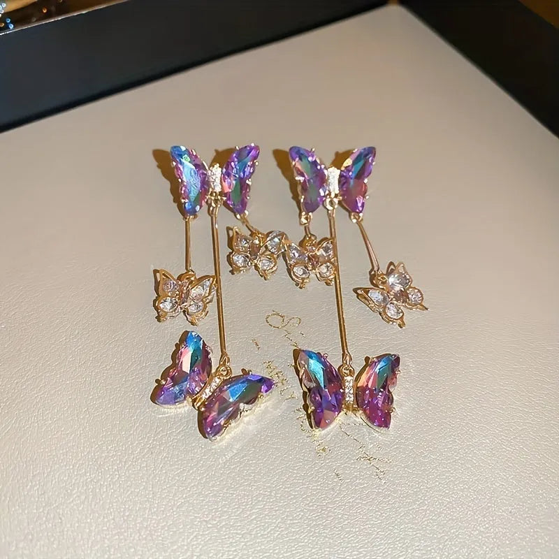Blue purple butterfly earrings with silver needle crystal flowers and tassel detailing on alloy base