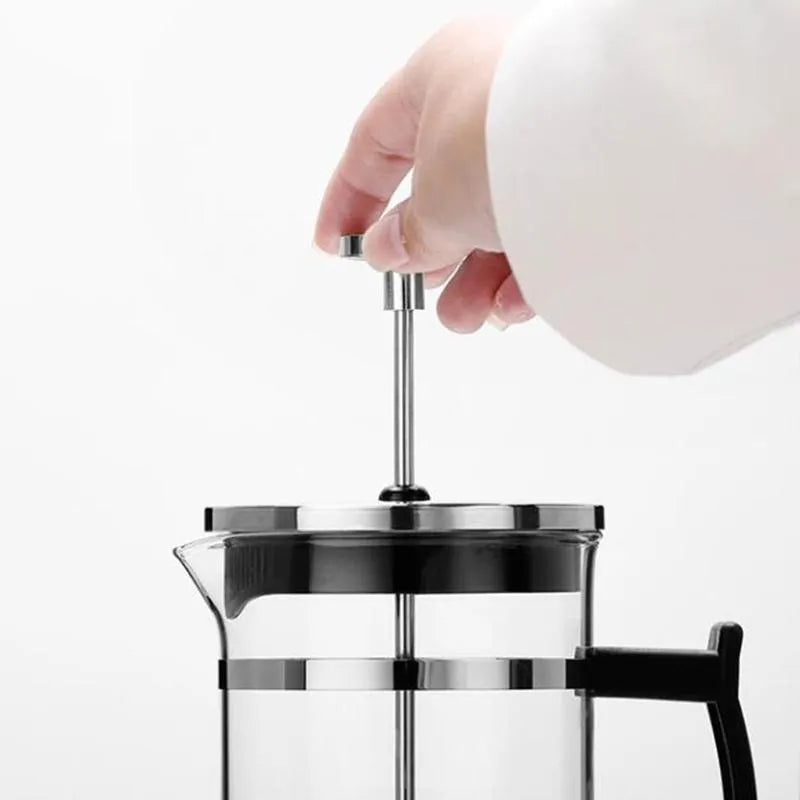 Small glass French press coffee maker with stainless steel plunger, shown with dimensions 10cm by 8cm by 17cm.