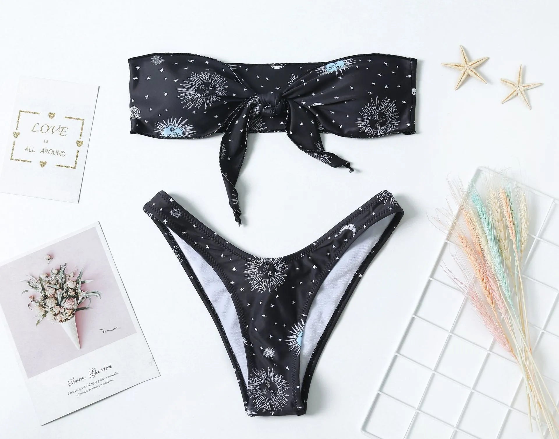 Black one-piece swimsuit with a bikini print pattern, showing backless design.