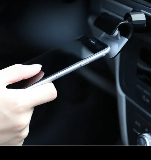 Black 360-degree rotating car phone holder mounted on a car air vent, holding a mobile phone.