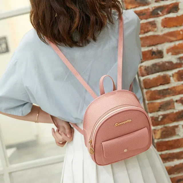 Small black PU women's shoulder backpack with zipper closure showing compact dimensions