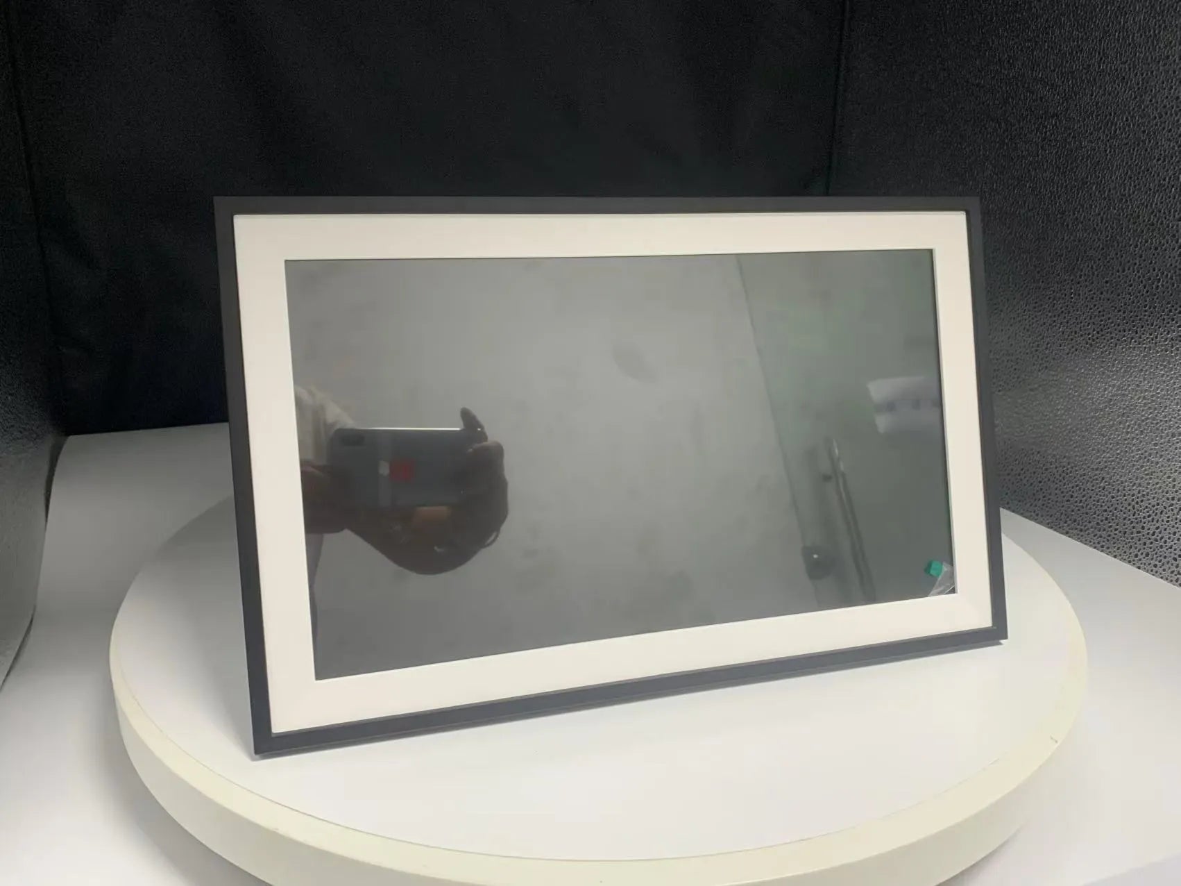 White 15.6-inch digital photo frame displaying family photos with smartphone app control interface