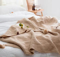 Nordic fringed knit acrylic blanket in beige colour draped over office chair