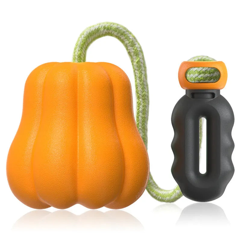 Large orange pumpkin-shaped plastic dog chew toy with an attached rope for throwing