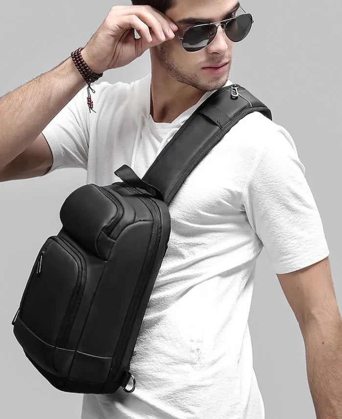 Black outdoor shoulder bag with air cushion strap showing internal laptop and organiser pockets