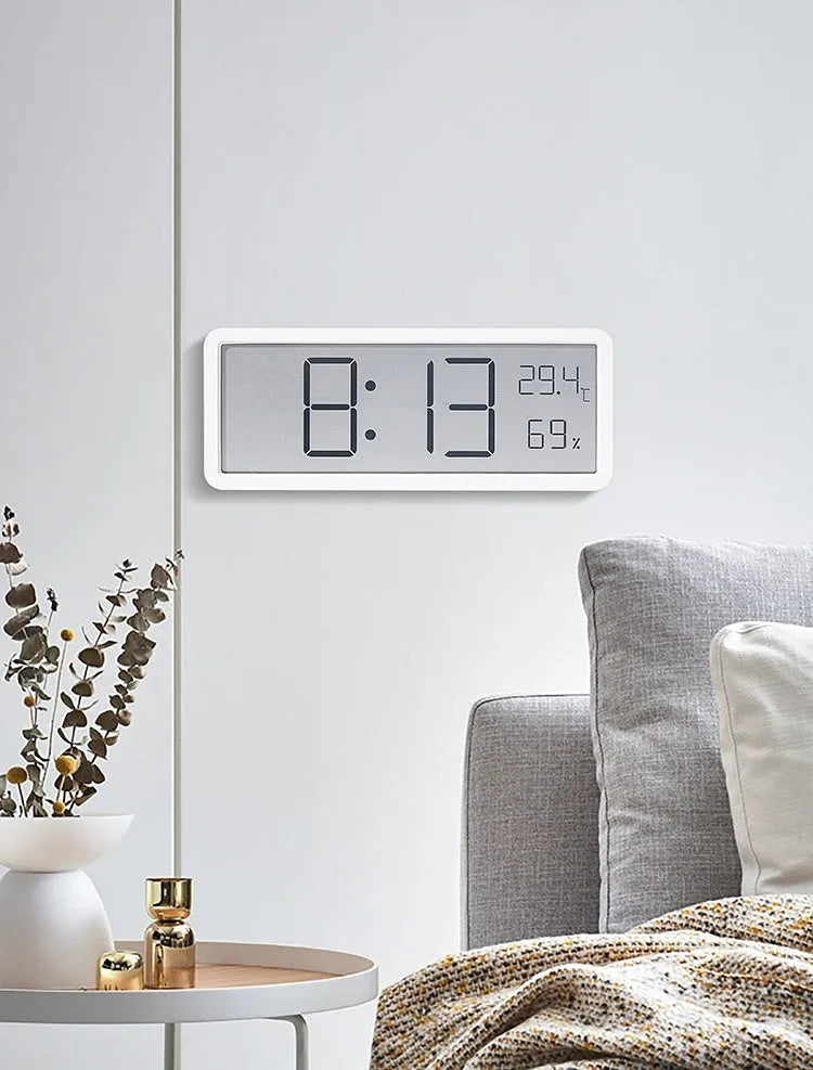 Simple large screen temperature and humidity clock in plastic with Nordic style, black colour, on a desk.