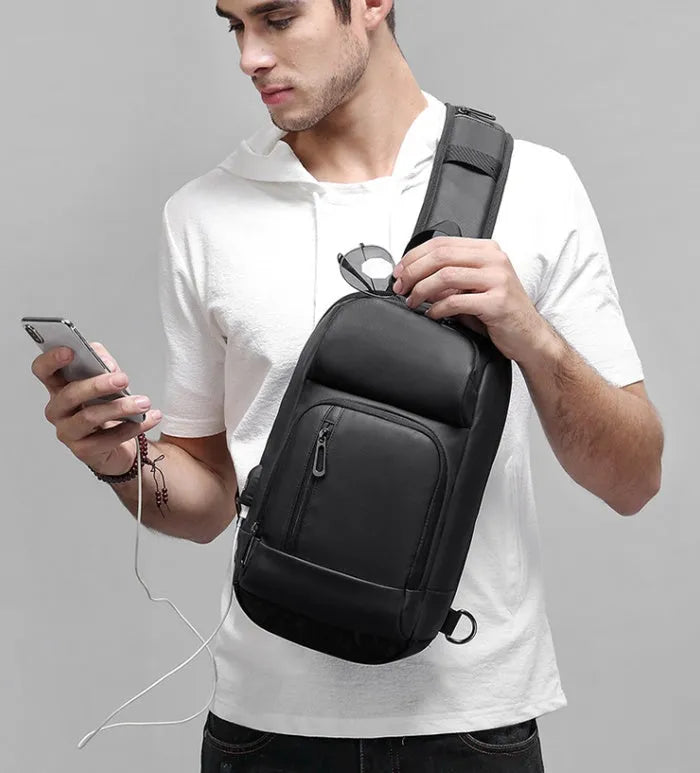 Black outdoor shoulder bag with air cushion strap showing internal laptop and organiser pockets