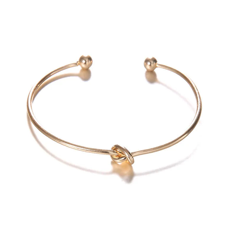 Gold Maili women's vintage cuff bracelet with arrow knot design.