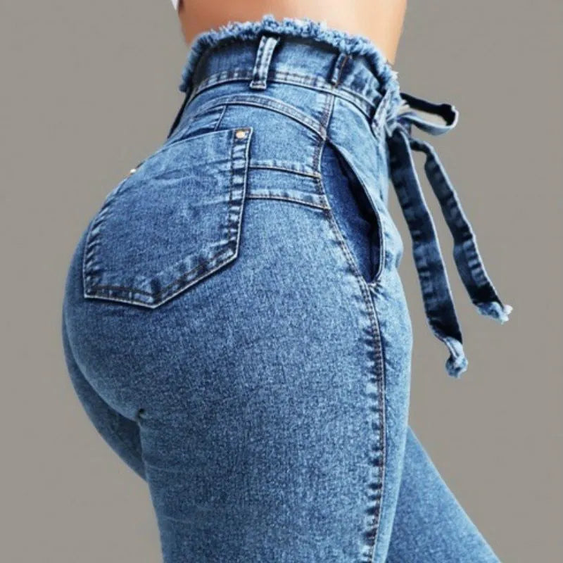 Fringed jeans with frayed hem in cowboy fabric, shown in light blue, on a neutral background.